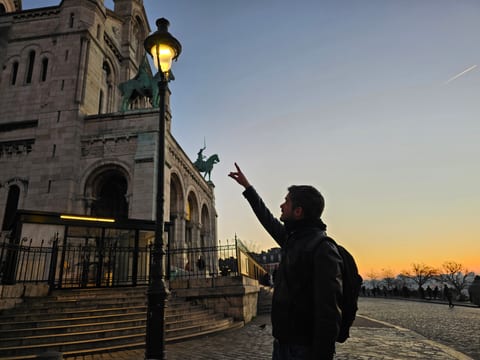 A guide pointing toward Sacre-Coeur in Montmartre at sunrise